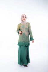 Fototapeta premium Beautiful female model in poses wearing traditional apparel and hijab, an urban lifestyle look for Muslim women isolated on white background. Beauty and hijab fashion concept. Full length
