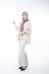 Beautiful female model in poses wearing traditional apparel and hijab, an urban lifestyle look for Muslim women isolated on white background. Beauty and hijab fashion concept. Full length