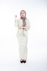 Beautiful female model in poses wearing traditional apparel and hijab, an urban lifestyle look for Muslim women isolated on white background. Beauty and hijab fashion concept. Full length