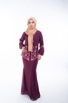 Beautiful female model in poses wearing traditional apparel and hijab, an urban lifestyle look for Muslim women isolated on white background. Beauty and hijab fashion concept. Full length