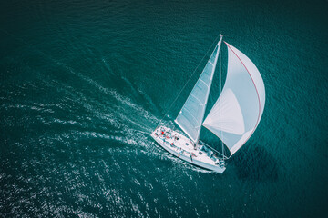 Regatta sailing ship yachts with white sails at opened sea. Aerial view of sailboat in windy condition - 513677259