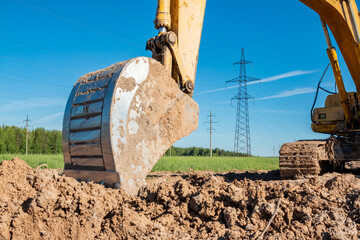 Excavator on the background of power lines.