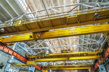 Beam cranes inside an industrial metal manufacturing plant.