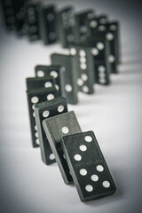 Black dominoes chain on table background
