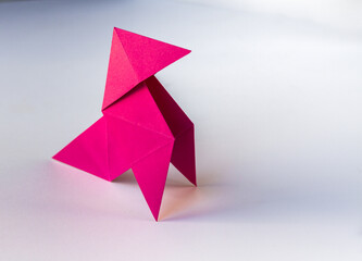 Pink paper hen origami isolated on a white background