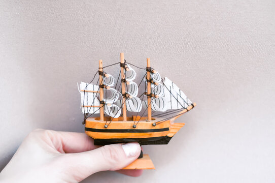 Tiny wooden toy ship on pastel background copy space. High quality photo