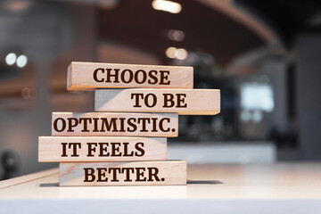 Wooden blocks with words 'Choose to be optimistic. It feels better'.