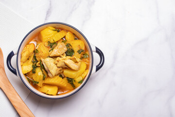 Chicken and Potato Curry with Basil Leaves in a Thai White Bowl
