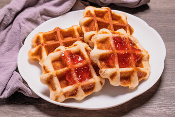 Four waffles in a white plate.and gray background.