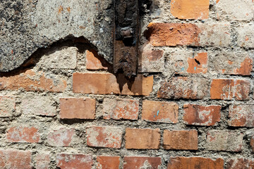 Old wall with rusty steel beam and crumbling plaster