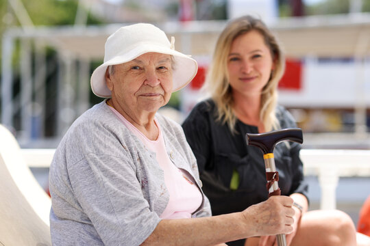 Senior Woman With Guardian On Walk In Summer