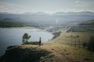 Young woman in sunglasses explores the hilly terrain of Siberia
