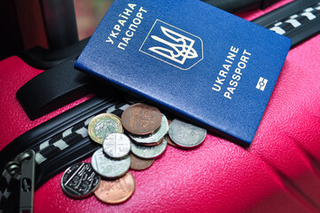 Ukrainian international passport pences and pink travel bag of refugee.