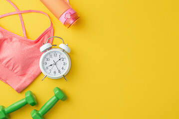 Sports concept. Top view photo of pink sports bra bottle of water alarm clock and dumbbells on isolated yellow background with copyspace