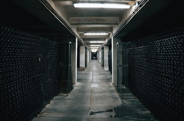 Typical underground cellar for storing and aging wine in glass bottles. Winemaking concept.