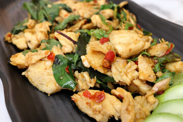 Thai style stair fried basil chicken on dark plate