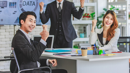 Asian millennial professional successful male businessman mentor in black formal suit standing helping two female employee sitting working with laptop computer at workstation in company meeting room