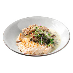 Isolated portion of chicken breast with quinoa and herbs