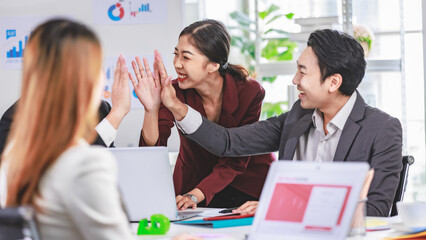 Portrait shot Asian young happy cheerful confident millennial professional successful female businesswoman in formal suit sitting crossed arms smiling while colleagues working in blurred background
