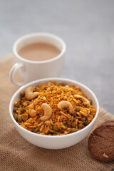 Close-Up of crunchy Indian mixture snacks with hot tea or Coffee time and handmade cookies (biscuits). Studio shoot at declined angle.