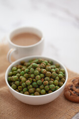 Close-Up of crunchy Indian mixture snacks with hot tea or Coffee time and handmade cookies (biscuits). Studio shoot at declined angle.