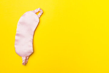 Sleeping eye mask on color background, top view