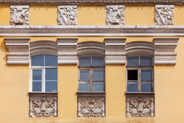 The windows of the old building decorated with stucco in the Soviet style