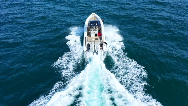 Aerial drone tracking video of luxury inflatable speed boat cruising in deep blue Aegean sea, Mykonos island, Cyclades, Greece