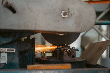 Close-up on the sides fly bright sparks from the angle grinder machine,Metal sawing. Hot sparks at grinding steel material.