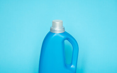 Blue plastic bottle stands on blue background. Conditioner or liquid powder for washing. Capacity with space for copying. Layout for logo application.
