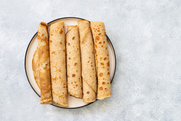 Fresh sweet pancakes rolled up on plate. Space for text