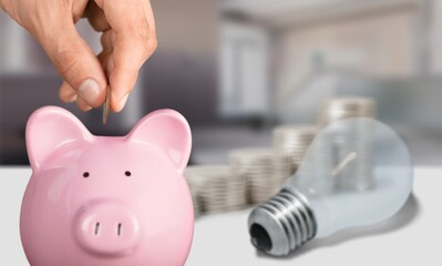 A light bulb on a pile of coins Energy saving and accounting concepts in the office concept.