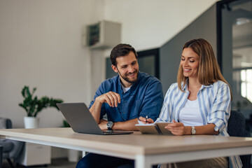 Two colleagues working together over the laptop.