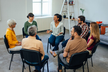 Top view of a group of people, sitting in a circle, talking about their mental health.