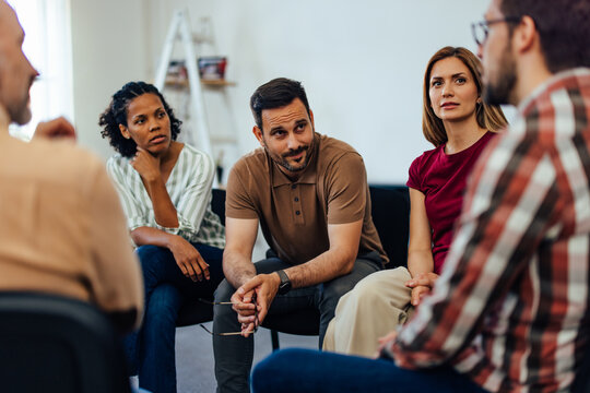 Serious-looking people, listening to one male's problems about his mental health.