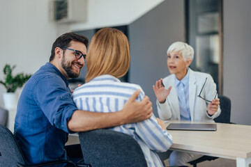 Fototapeta premium Focused female insurance agent talking to a couple at the office.