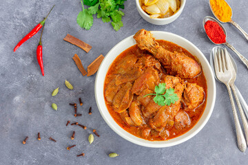 Flavourful Chicken Do Pyaza in a Bowl with Assorted Spices Top Down Photo
