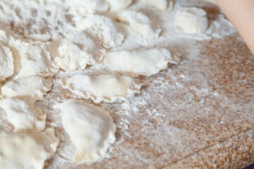 group of raw dumplings lie on granite table.