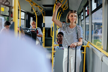 Woman in shuttle bus looking through window - obrazy, fototapety, plakaty