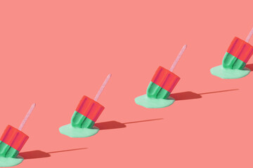 Colored red green ice cream melts from the hot sun. Hot weather concept