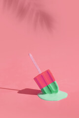 Colored ice cream melts from the hot sun. Palm leaves shadow. Hot weather concept. Vertical format