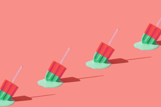 Colored red green ice cream melts from the hot sun. Hot weather concept