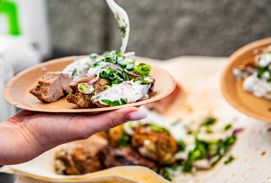 Woman Hand Holding Paper Plate With Meat Outdoor