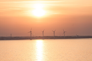 Sun setting over wind turbines on a summer evening..