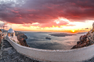 Old Town Thira on the Santorini island, famous churches against caldera with sunset over sea in...