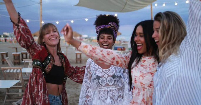 Multiracial female friends having fun dancing together outdoor at beach party
