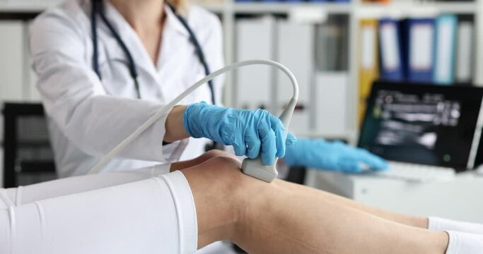 Doctor conducts ultrasound examination of patient knee in clinic