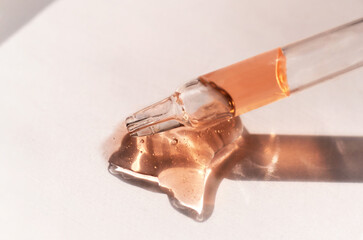 Pipette with orange gel, transparent fluid hyaluronic acid. Cosmetics, science and healthcare concept closeup. Dose of retinol. Front view, high angle shot. Beauty product closeup, banner