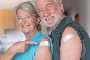 Beautiful smiling caucasian senior couple 70s after receiving the booster for omicron variant of...