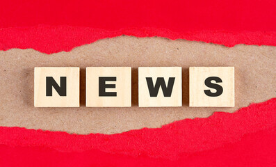 NEWS word on wooden cubes on red torn paper , financial concept background